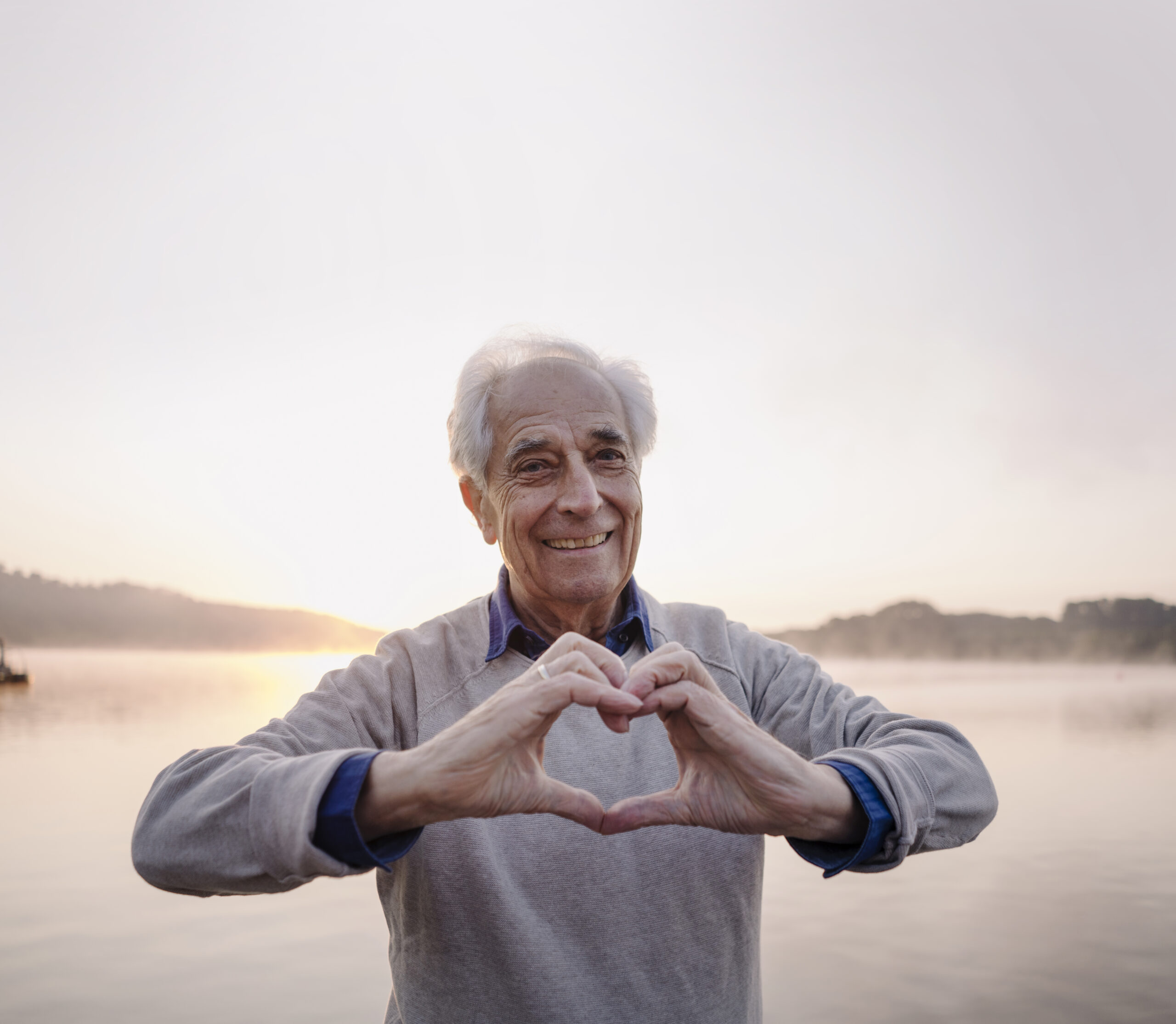Ein älterer Patient formt mit seinen Händen ein Herz als Symbol dafür, dass DiGA ProHerz ihm geholfen hat.